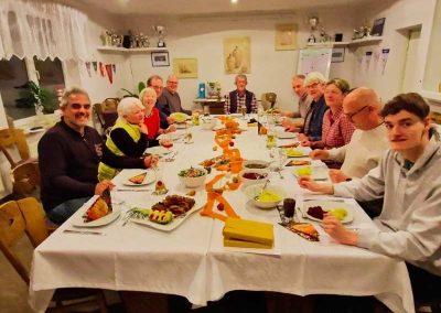 Mitglieder des Schachclubs Büsum sitzen an einem großen Tisch, sind zur Hauptmitgliederversammlung zusammengekommen und werden in Kürze mit dem Essen beginnen.