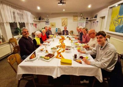 Mitglieder des Schachclubs Büsum sitzen an einem großen Tisch, sind zur Hauptmitgliederversammlung zusammengekommen und werden in Kürze mit dem Essen beginnen.